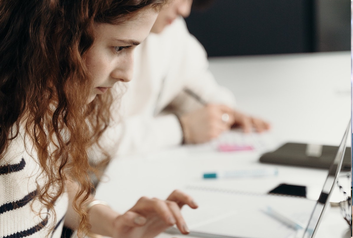 Fokuseret elev arbejder på en bærbar computer ved et skrivebord