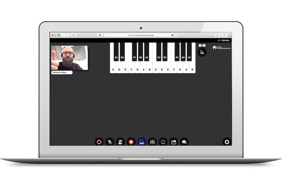 Brugerflade for online musiklektion med virtuelt klaver og lærer på videoopkald, der giver tommel op.